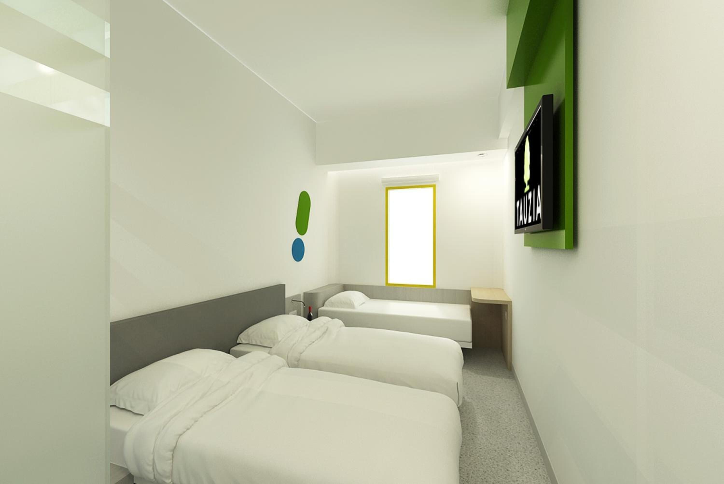 A hotel room with two beds, a TV, a small desk, and a window with a yellow frame.