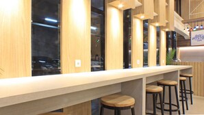 A modern bar area with wooden accents and bar stools. -  POP! Hotel Festival Citylink Bandung (Bandung)