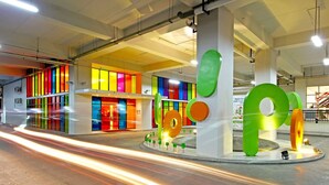 A modern building with colorful vertical panels and large abstract sculptures. -  POP! Hotel Festival Citylink Bandung (Bandung)