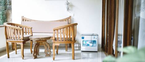 A wooden dining set with a table and chairs, a water dispenser, and a wall-mounted light fixture.
