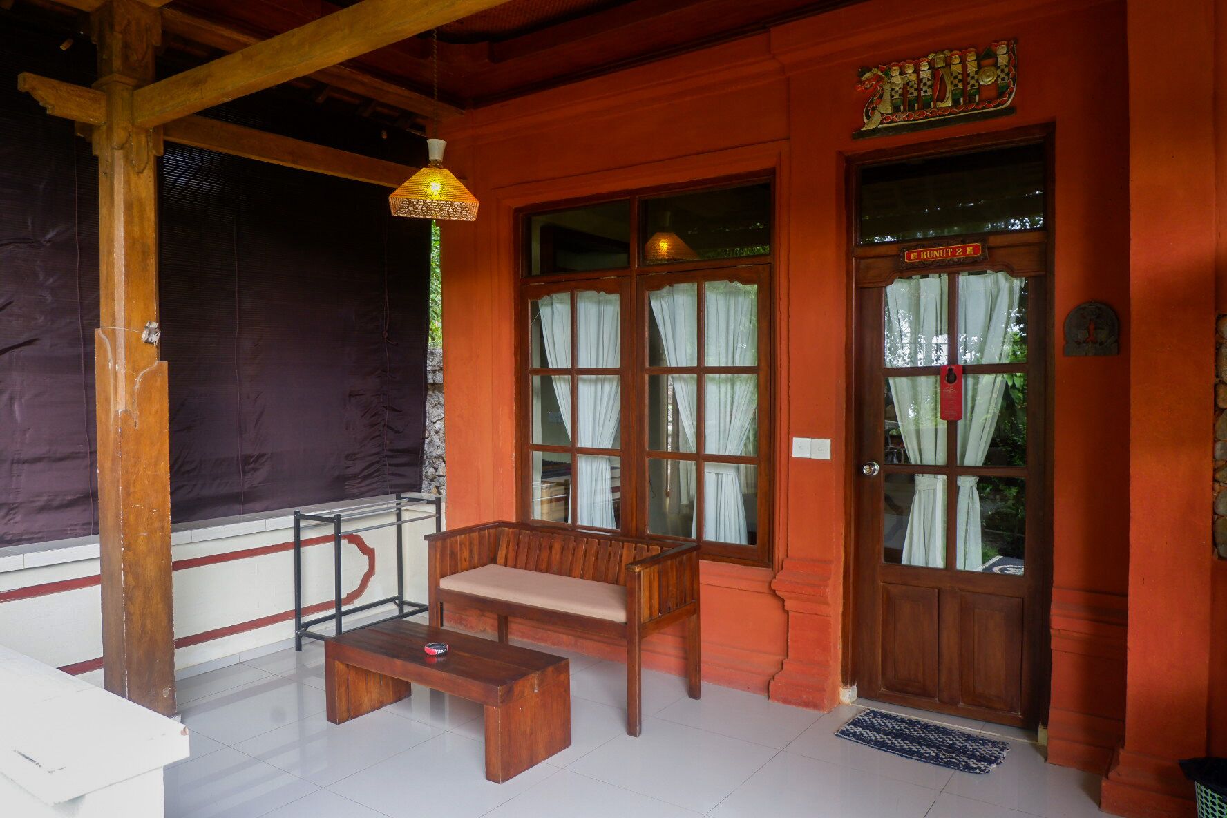 A wooden bench and table in a room with large windows and a door marked "HUNINTU".