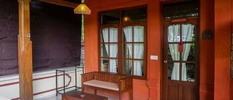 A wooden bench and table in a room with large windows and a door marked "HUNINTU".