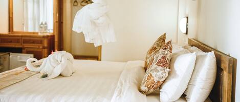 A hotel room with a bed, a wooden headboard, a mirror, and a wooden cabinet.