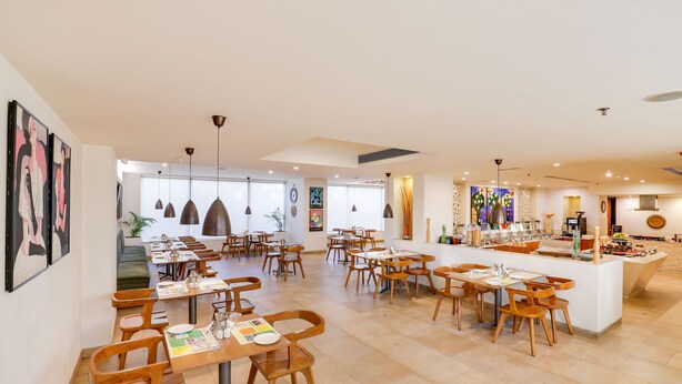 A spacious restaurant with multiple dining areas, wooden furniture, and a central island with a bar. - Lemon Tree Hotel, Chandigarh (Chandigarh)