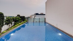A rooftop swimming pool with a clear view of the cityscape in the background. - Lemon Tree Hotel, Chandigarh (Chandigarh)