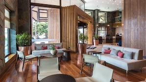 Un interior moderno con piso de madera, áreas de estar y ventanas amplias.