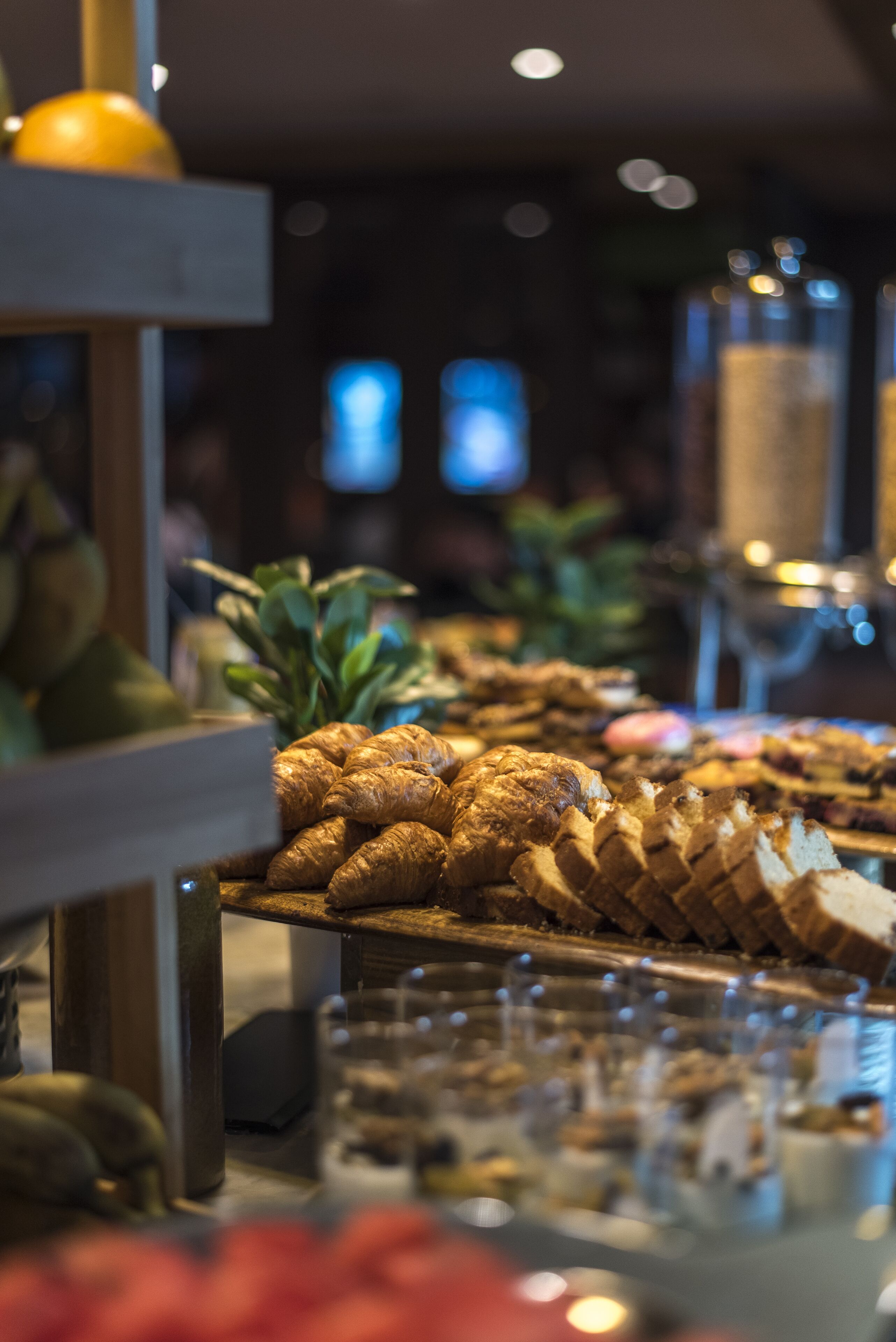 A buffet with various food items including pastries and fruits.