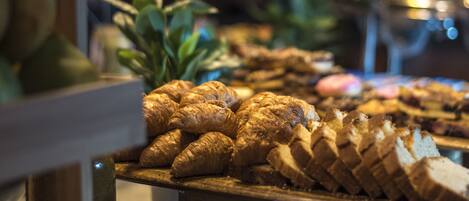 Un bufé con diversos alimentos, incluyendo pasteles y frutas.