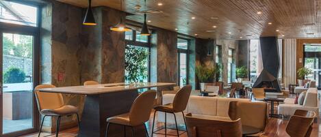 Un restaurante moderno con barra, suelo de madera y paredes de piedra.