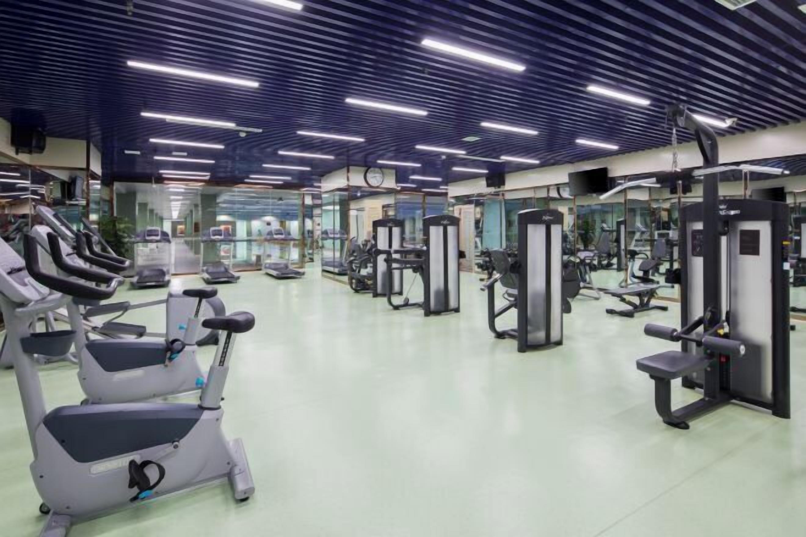 Ett gym med löpband, styrketräningsmaskiner och fria vikter.