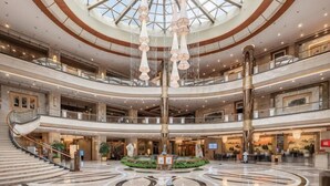 Un atrium de diversos nivells amb una escala central, una gran pèndol i un disseny de sòl circular.