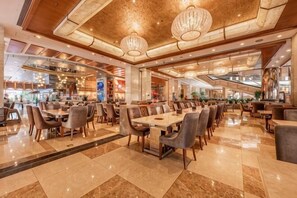 A spacious hotel dining area with multiple tables and chairs, a high ceiling with chandeliers, and a modern interior design. - Empark Grand Hotel (Anhui) (Hefei)