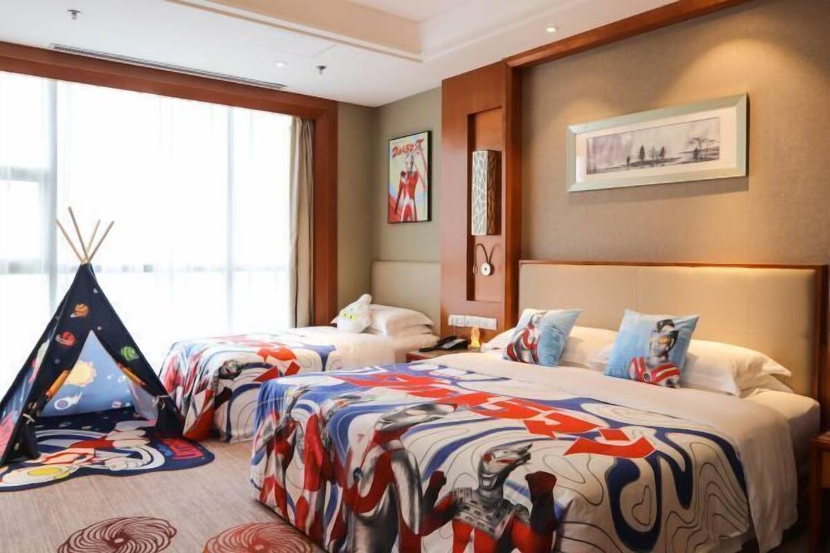 Une chambre d’hôtel avec deux lits, une grande fenêtre, une œuvre d’art accrochée au mur et une tente décorative.