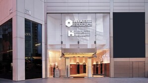 The exterior of a hotel with a modern design, featuring a prominent sign for the hotel and a reception area. - Hyatt House London Stratford (London)