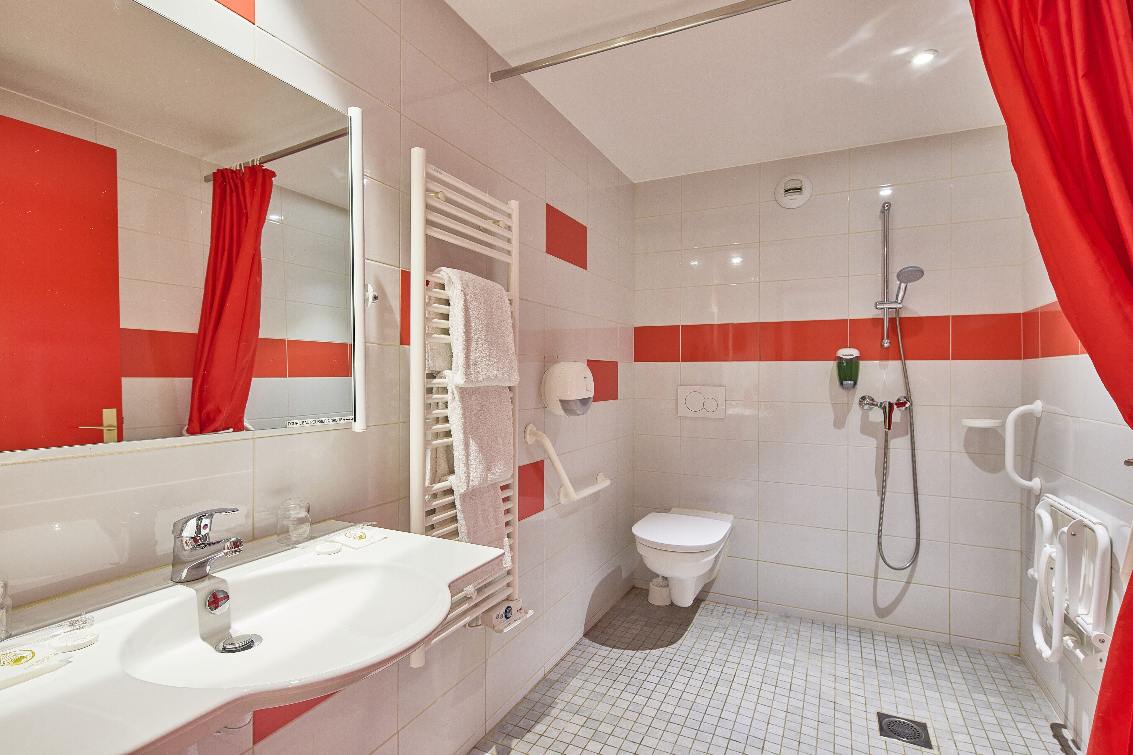 Une salle de bain avec un lavabo blanc, des toilettes et une douche.