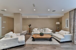 A modern living room with a sofa set, a coffee table, and a lamp.
