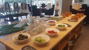 A buffet setup with various food items including salads, vegetables, and bread baskets. - Glarun Jinling Hotel Nanjing (Nanjing)