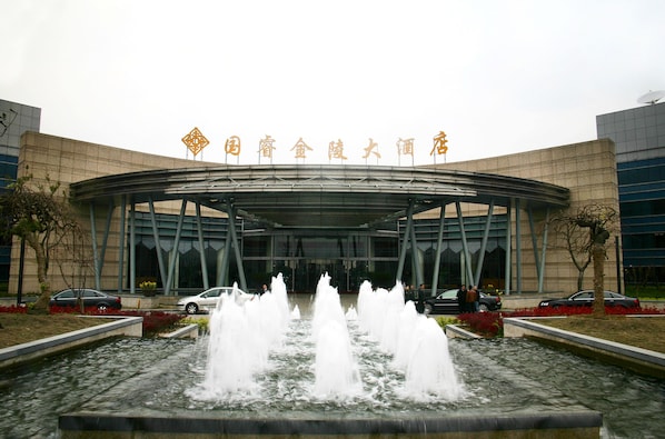 A modern building with a large entrance and a water fountain in front. - Glarun Jinling Hotel Nanjing (Nanjing)