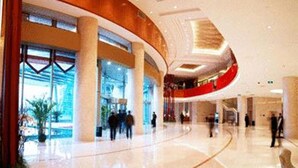 A spacious lobby with a curved ceiling, large windows, and a polished floor. - Glarun Jinling Hotel Nanjing (Nanjing)