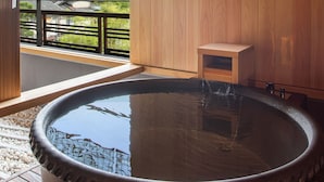 A hot spring bath with a wooden bench and a small wooden cabinet. - Ryotei Rangetsu (Kyoto)