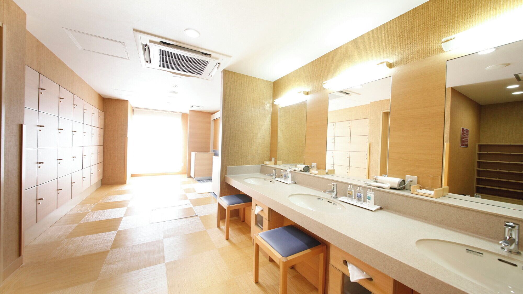 Un bagno moderno con un ampio lavabo, diversi lavandini e uno specchio grande.
