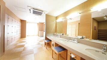 Un bagno moderno con un ampio lavabo, diversi lavandini e uno specchio grande.