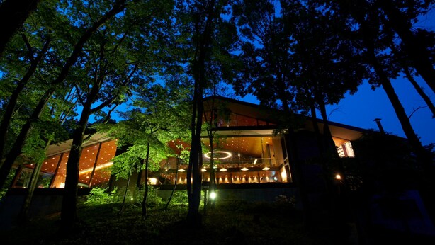 Un bâtiment moderne doté de grandes fenêtres et d’un élément décoratif lumineux circulaire au centre.
