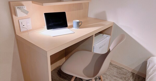 A small, neatly organized workspace with a laptop, a mug, and a chair.