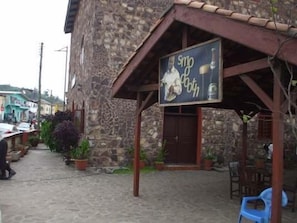 A stone building with a sign advertising 'Smo' and 'Café'. - Coconut Grove Bridge House (Elmina)