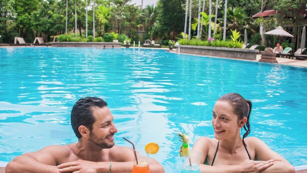 A couple relaxing by a pool with drinks. - THE PRIVILEGE FLOOR by Borei Angkor (Siem Reap)