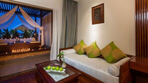 A modern living room with a sofa, cushions, a coffee table with fruit, and a view of the outdoors. - THE PRIVILEGE FLOOR by Borei Angkor (Siem Reap)