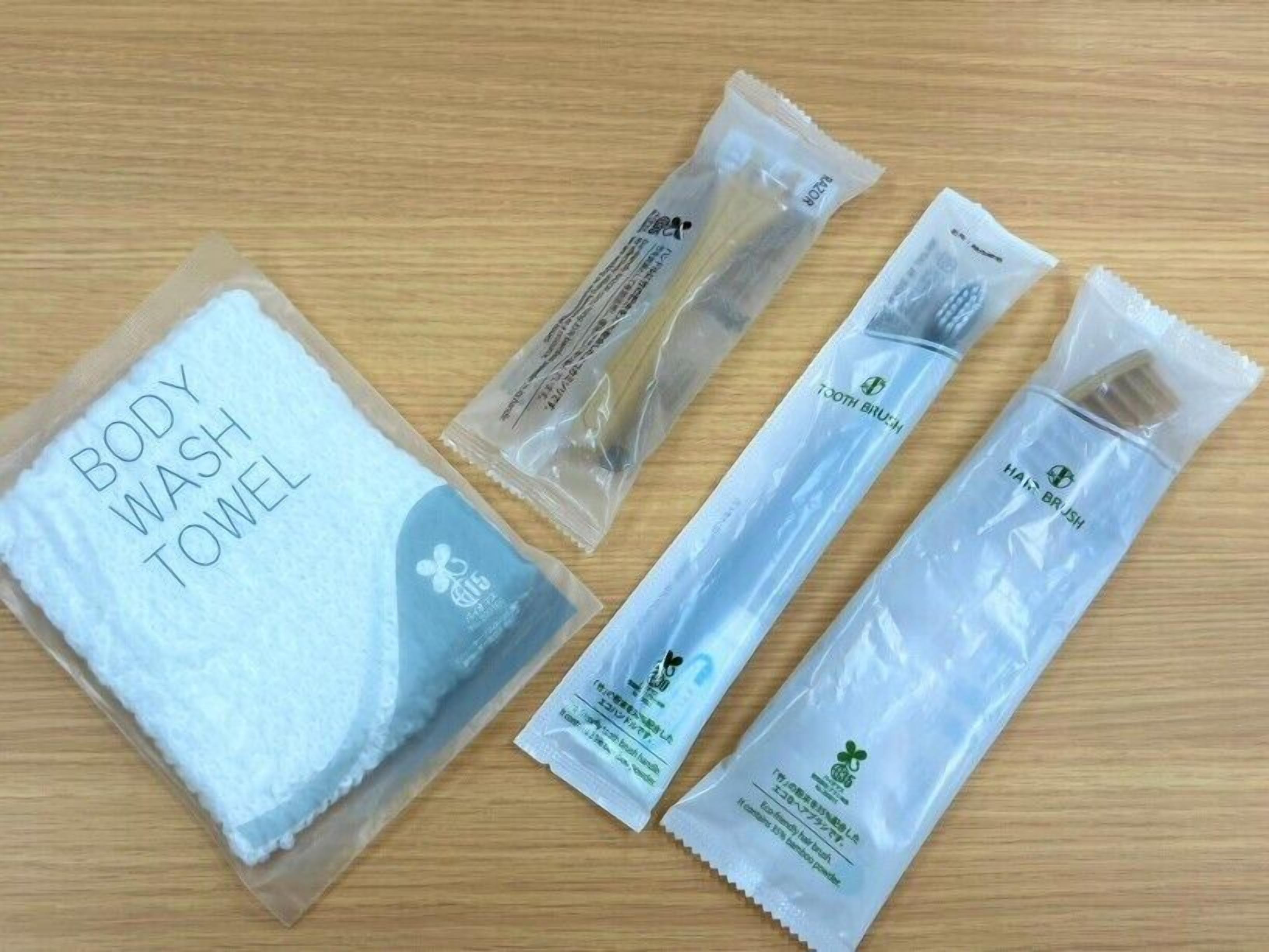 A body wash towel, a toothbrush, and a hair brush on a wooden surface.