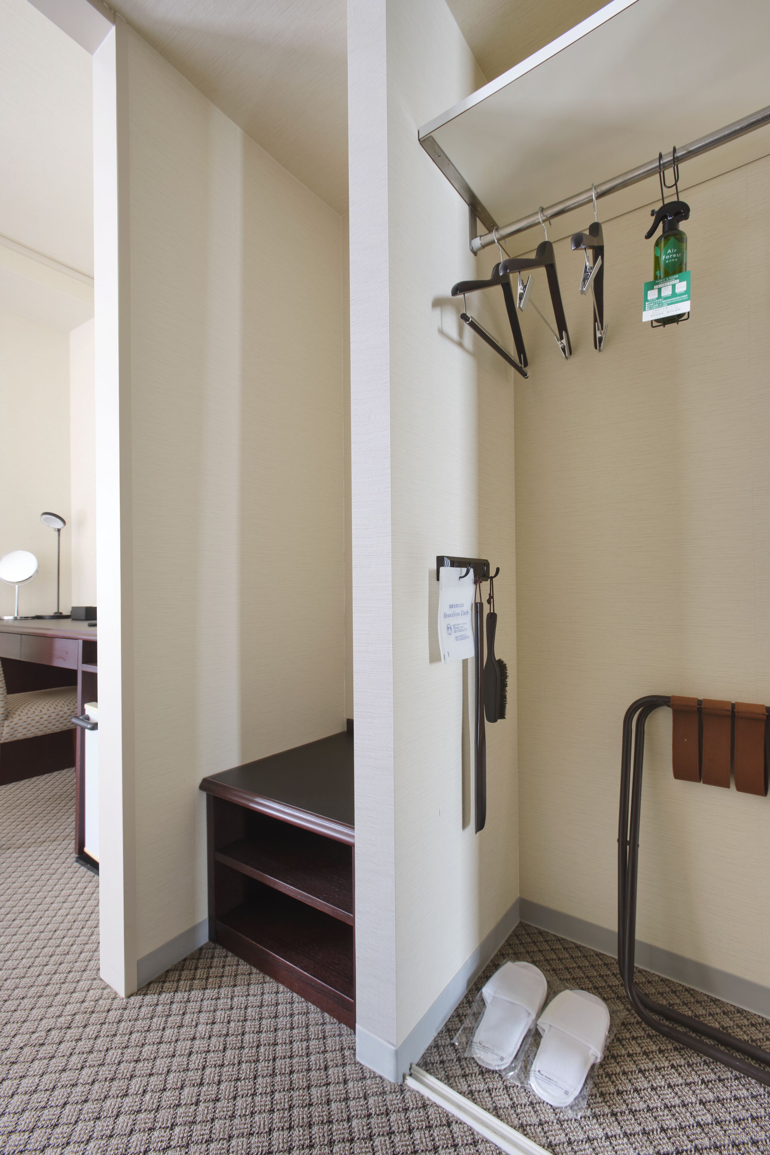 Un baño de hotel con ducha, toallero y espejo.