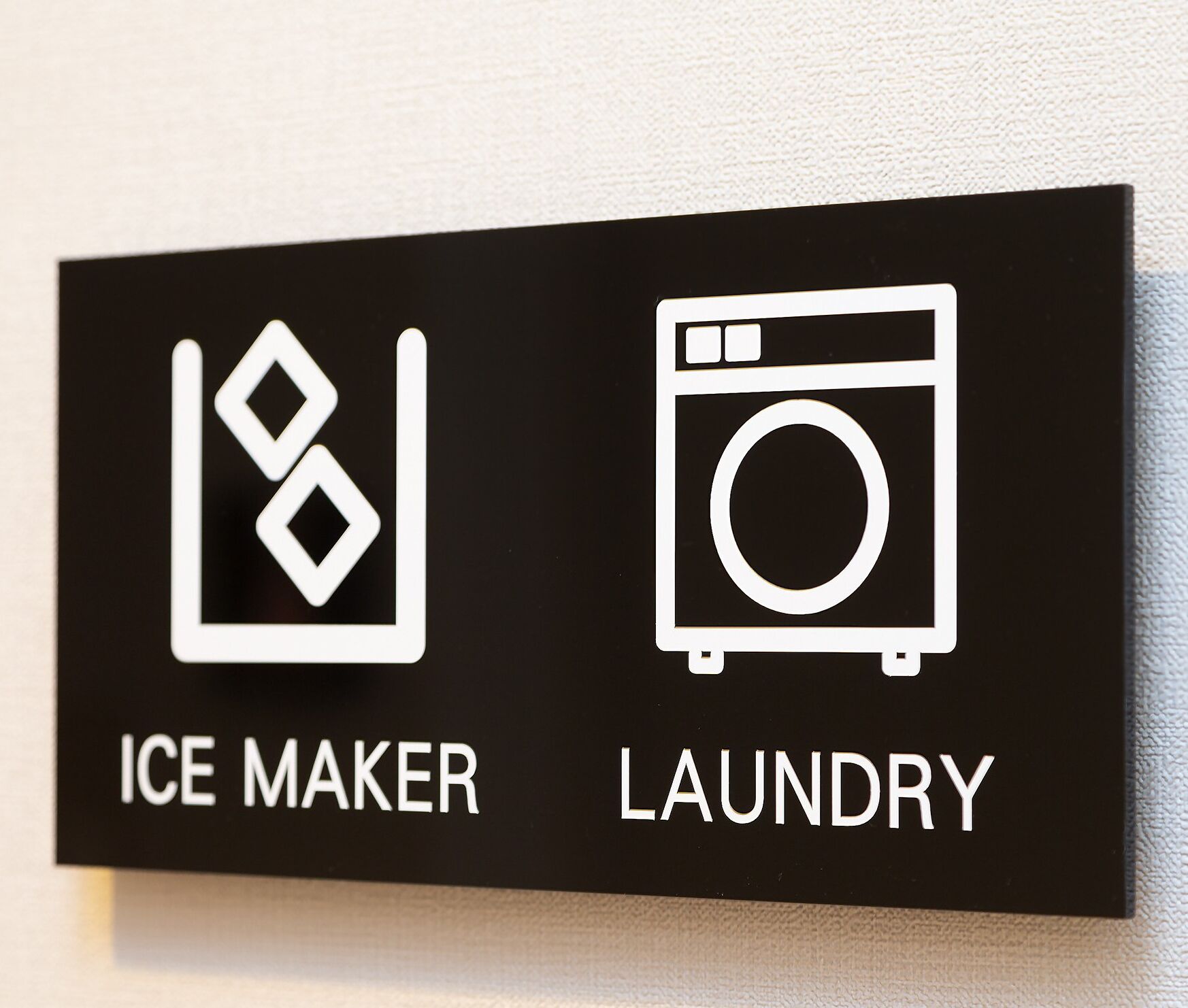 A sign with icons indicating an ice maker and laundry services.