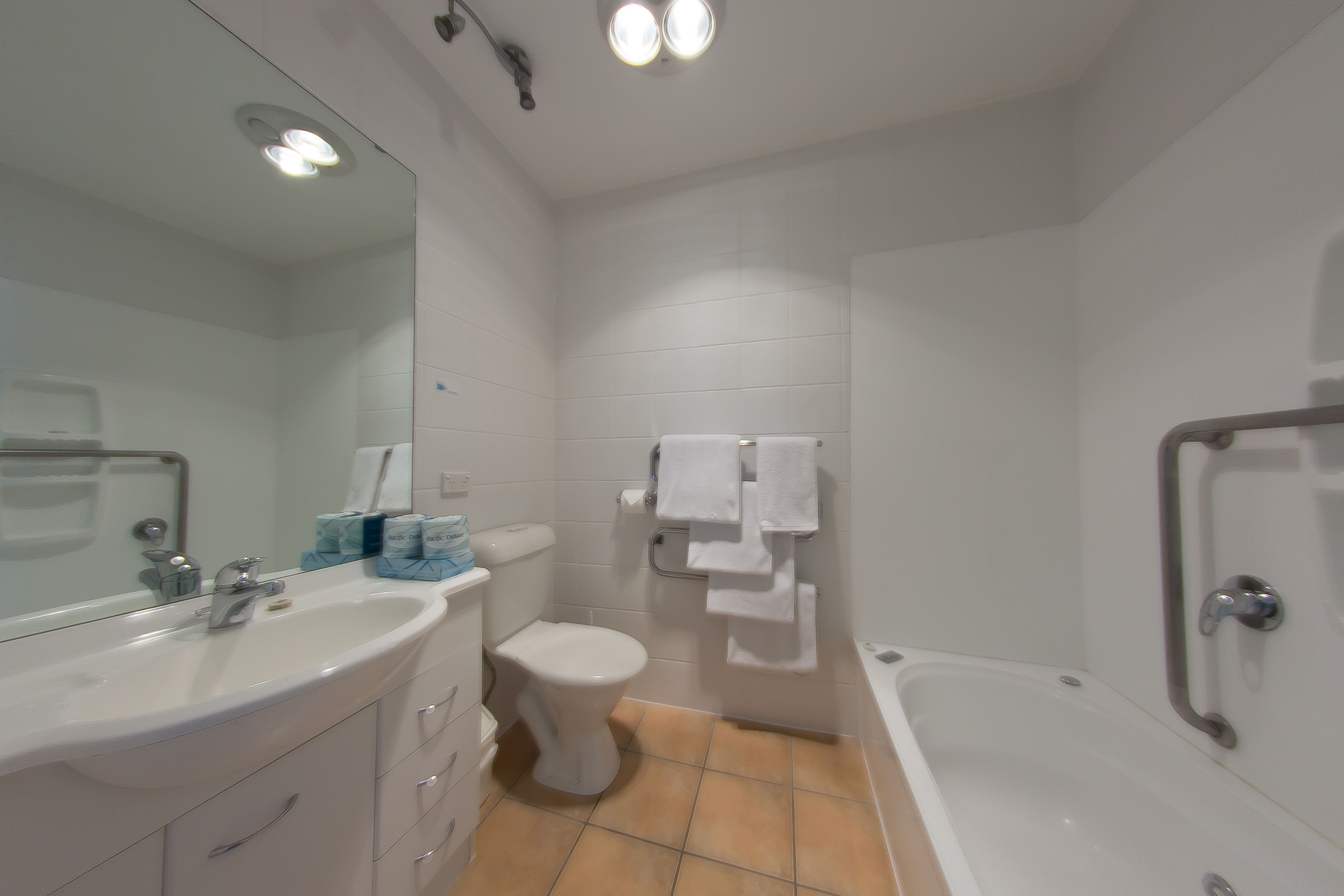 Et badeværelse med vask, toilet og badekar.