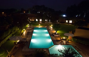 A rectangular swimming pool with a surrounding deck, lounge chairs, and umbrellas. - Lemon Tree Hotel Tarudhan Valley (Taoru)