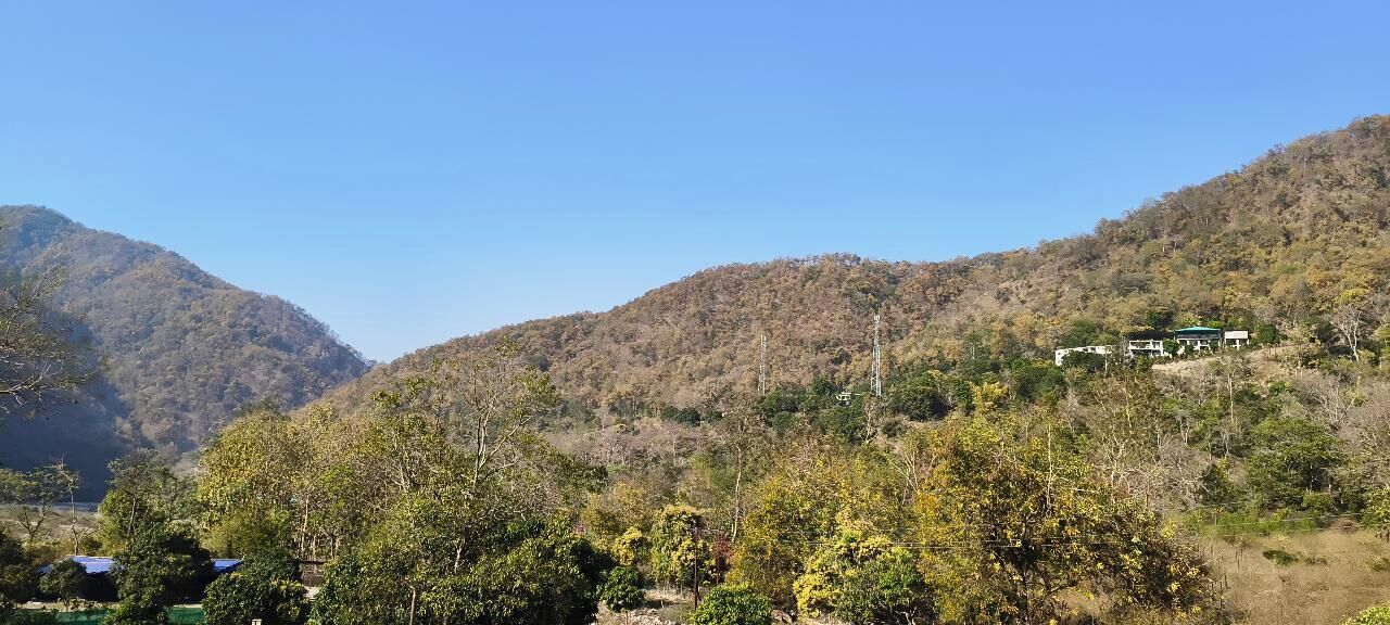 Un paisaje montañoso con algunos edificios en una colina.