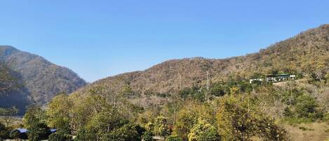 Un paisaje montañoso con algunos edificios en una colina.