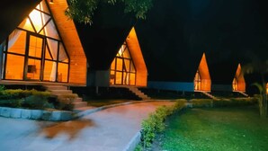 Una hilera de edificios modernos con techos triangulares y amplios ventanales, unidos por un sendero.