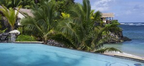 Una piscina al aire libre, sombrillas, sillones reclinables de piscina