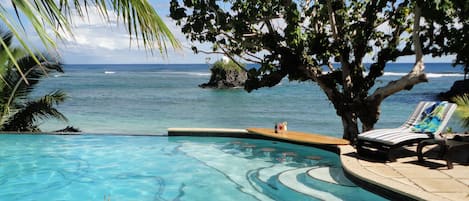 Una piscina al aire libre, sombrillas, tumbonas