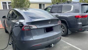 Un Tesla Model 3 cargándose en un aparcamiento.