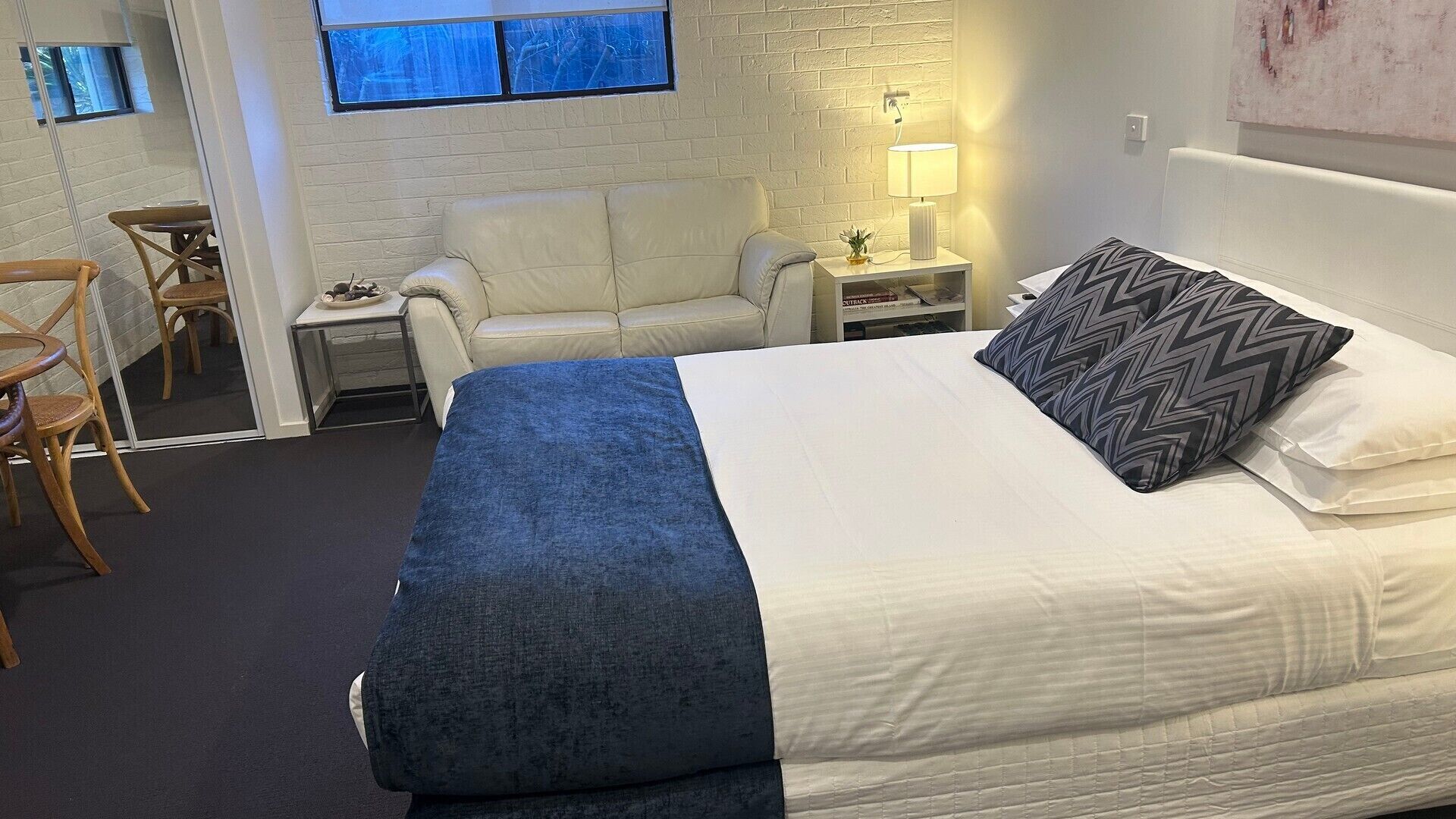 Una habitación de hotel con una cama, un sofá, una mesita y una silla.