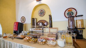 A breakfast buffet with various food items and a coffee machine. - Mare Monte (Ios)
