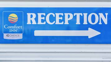 A blue sign with the Comfort Inn logo and the word "RECEPTION" with an arrow pointing to the right.