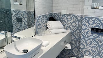 Une salle de bain moderne avec un lavabo blanc, un miroir et des toilettes.