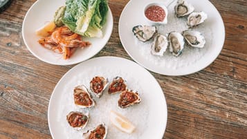 Three plates of seafood on a wooden table.