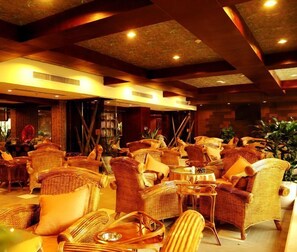 A spacious lounge area with wicker furniture and a warm, inviting atmosphere. - Huaxi Angel Hotel - Chengdu (Chengdu)