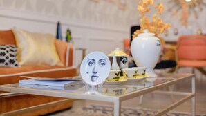 A modern living room with a sofa, a coffee table with a decorative plate, and a vase with flowers. - Huaxi Angel Hotel - Chengdu (Chengdu)