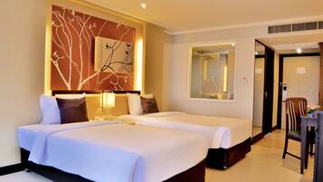 Quarto de hotel com duas camas, um espelho grande, uma cadeira de madeira e uma obra de arte na parede.